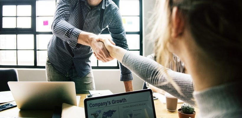 Consulting Background Handshake with a computer in the background.