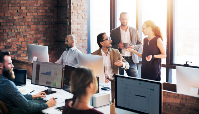 Employees huddled around computer.