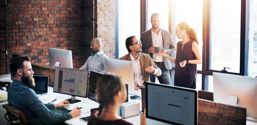 Managed IT Services Employees huddled around computer.